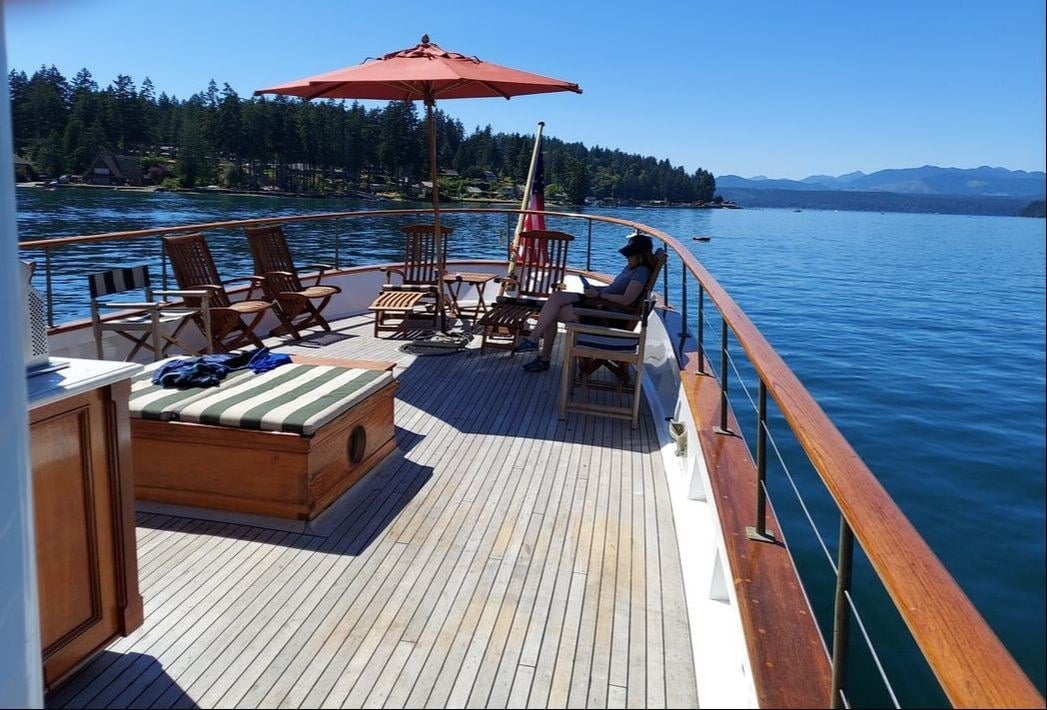 Teak chairs on Blue Peter’s aft deck, with open views across the water.