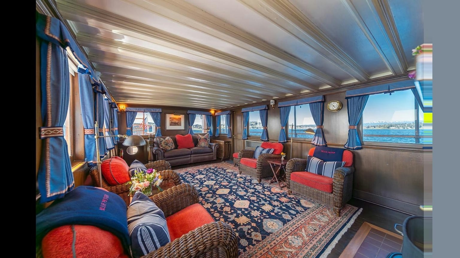 Blue Peter’s bright salon, with wicker seating, varnished wood and views across the water